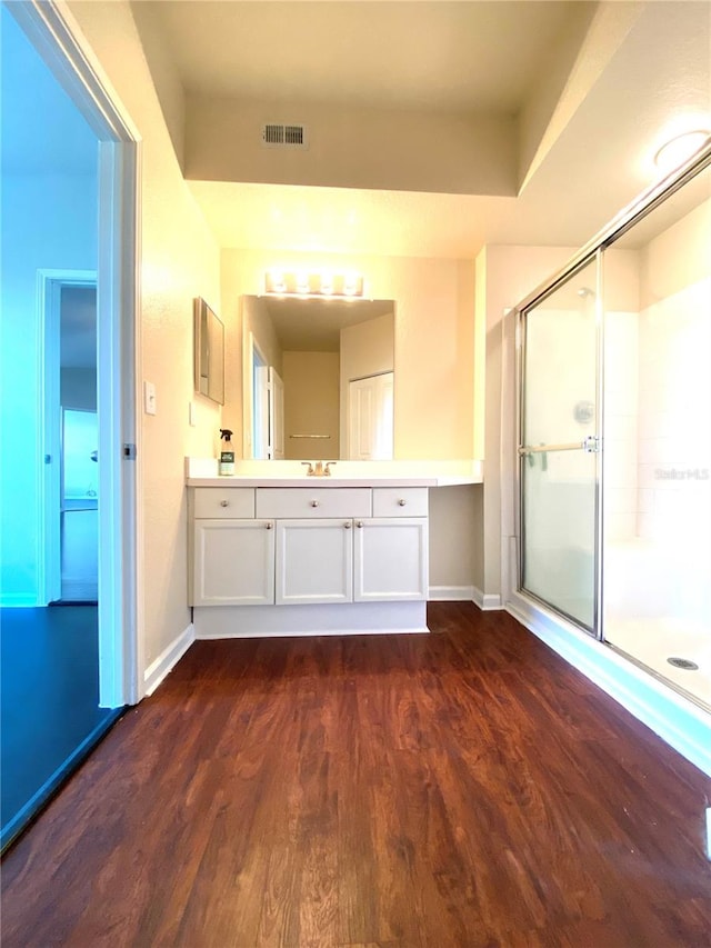 bathroom featuring hardwood / wood-style flooring, vanity, and a shower with shower door