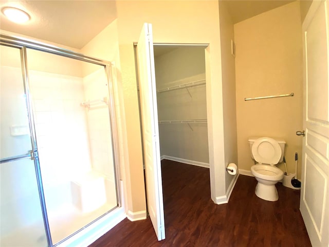 bathroom featuring hardwood / wood-style floors, toilet, and walk in shower