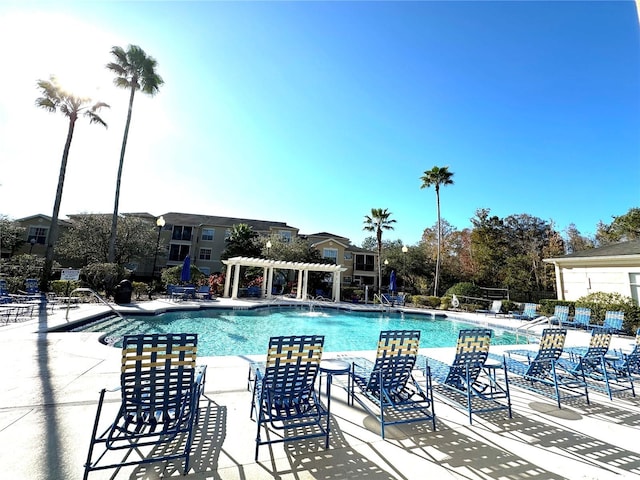 view of swimming pool featuring pool water feature and a pergola