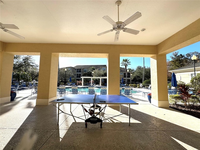 view of patio / terrace featuring ceiling fan, a community pool, and a pergola