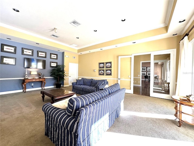 living room with crown molding, a tray ceiling, dark carpet, and french doors