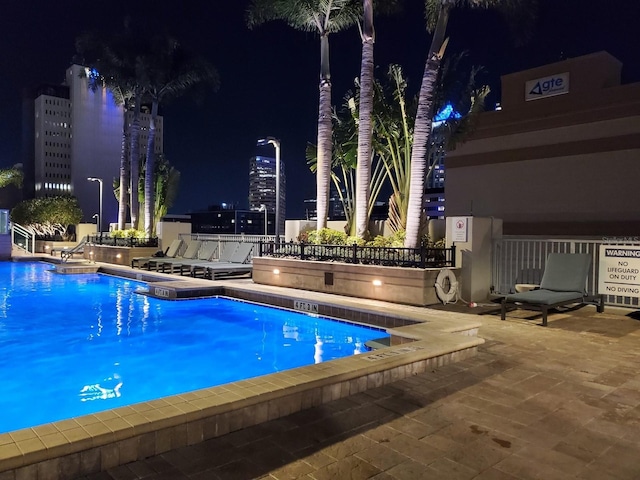 pool at night with a patio area