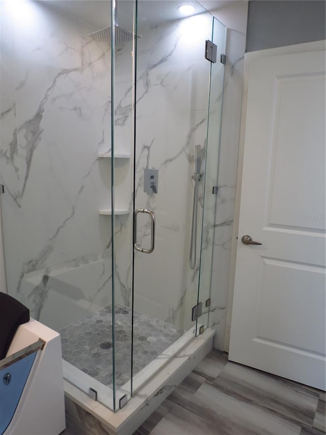 bathroom with hardwood / wood-style floors and an enclosed shower