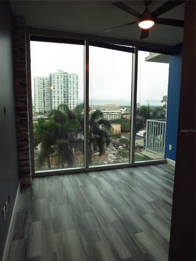 entryway featuring hardwood / wood-style flooring, ceiling fan, and expansive windows