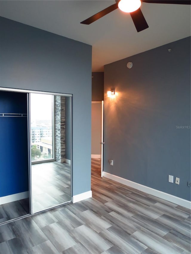 unfurnished bedroom featuring light hardwood / wood-style floors, a closet, and ceiling fan