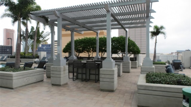 view of property's community with a pergola, an outdoor bar, and a patio area