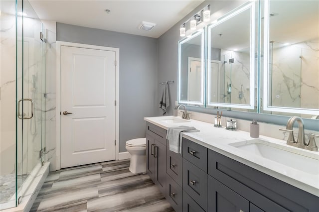 bathroom featuring hardwood / wood-style floors, vanity, toilet, and walk in shower