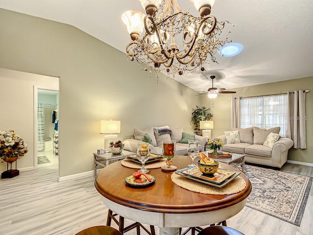 interior space featuring lofted ceiling, light hardwood / wood-style floors, and ceiling fan with notable chandelier