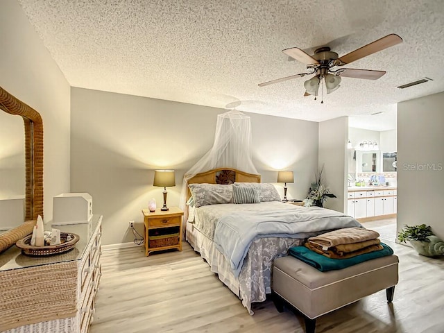 bedroom featuring a textured ceiling, ceiling fan, and light hardwood / wood-style flooring