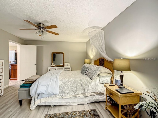 bedroom featuring a textured ceiling, light hardwood / wood-style floors, and ceiling fan