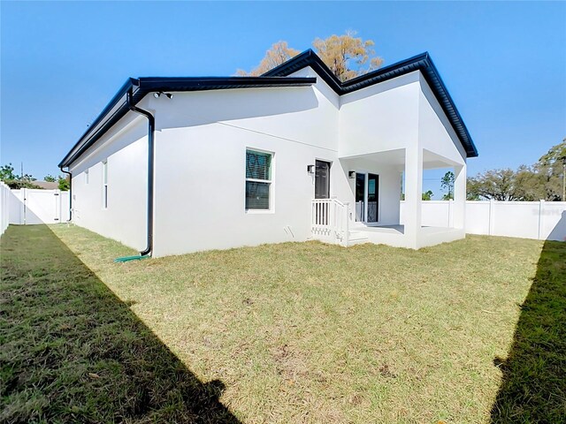 back of property featuring a lawn and a patio area