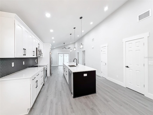 kitchen featuring sink, decorative light fixtures, a center island with sink, appliances with stainless steel finishes, and white cabinets