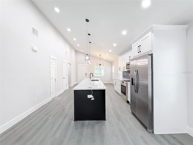 kitchen with sink, hanging light fixtures, a center island with sink, appliances with stainless steel finishes, and white cabinets