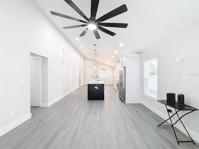 unfurnished living room with sink, light hardwood / wood-style flooring, high vaulted ceiling, and ceiling fan