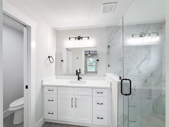 bathroom featuring vanity, an enclosed shower, ceiling fan, and toilet