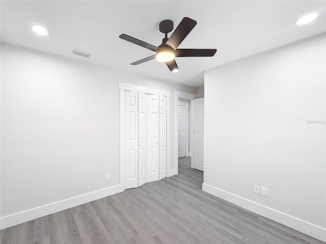 unfurnished bedroom featuring light hardwood / wood-style flooring, a closet, and ceiling fan