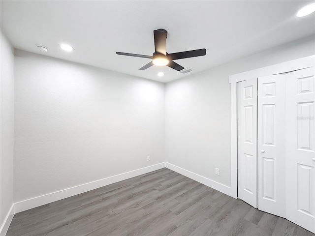 unfurnished bedroom featuring wood-type flooring, a closet, and ceiling fan