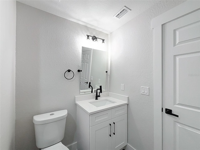 bathroom with vanity, a textured ceiling, and toilet