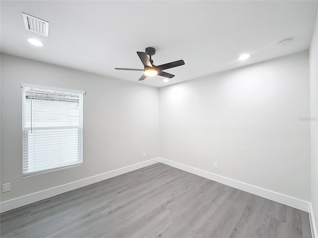 empty room with wood-type flooring, a healthy amount of sunlight, and ceiling fan