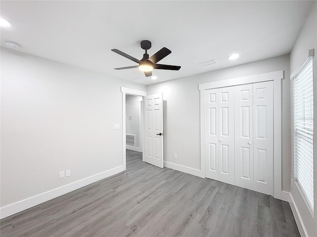 unfurnished bedroom with light hardwood / wood-style flooring, ceiling fan, and a closet