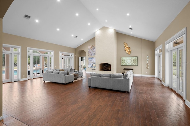 living room featuring a large fireplace, dark hardwood / wood-style flooring, high vaulted ceiling, and french doors