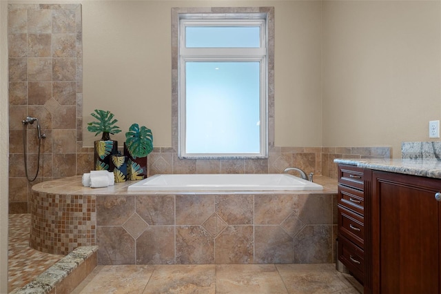 bathroom with vanity and tiled bath