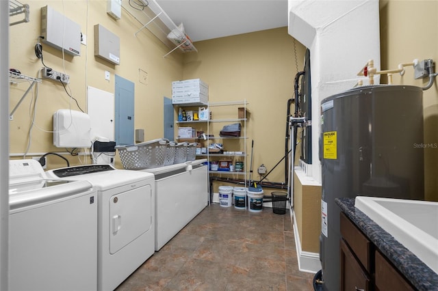 clothes washing area with cabinets, electric water heater, sink, washing machine and clothes dryer, and electric panel