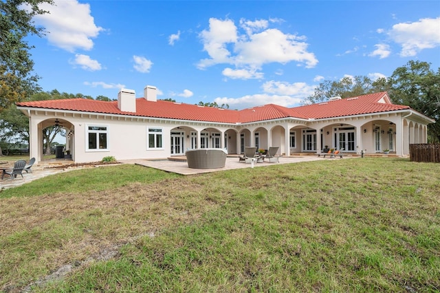 back of house with a lawn, ceiling fan, french doors, and a patio