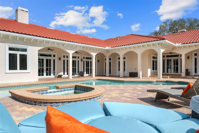 back of property with french doors, a patio, ceiling fan, and a pool with hot tub