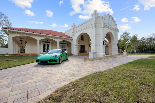 view of front of property with ceiling fan, french doors, and a front yard