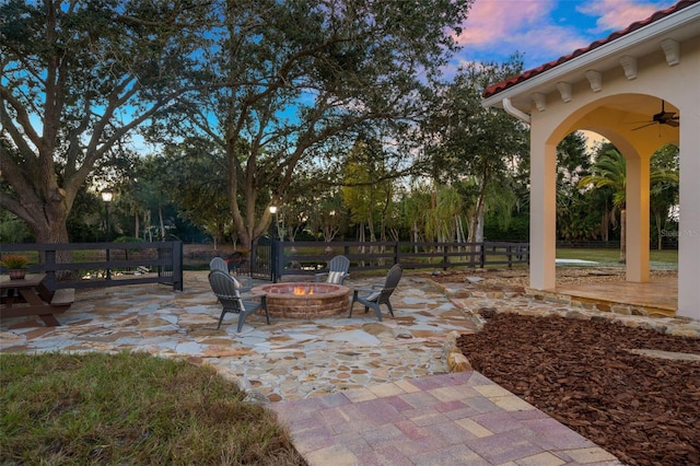 patio terrace at dusk featuring an outdoor fire pit