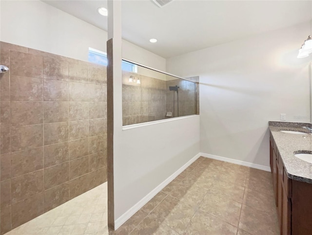 bathroom featuring vanity, tiled shower, and tile patterned floors