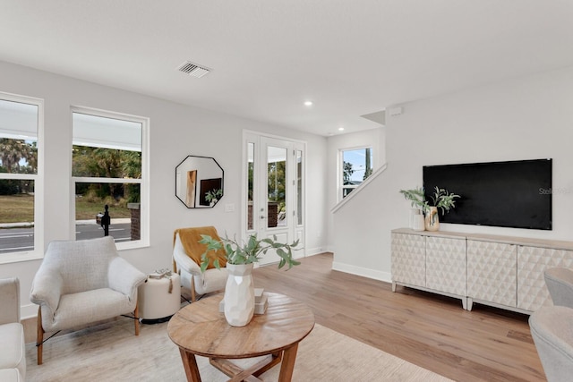 living room with a healthy amount of sunlight and light hardwood / wood-style floors