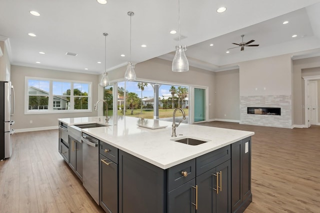 kitchen with pendant lighting, an island with sink, a wealth of natural light, and sink