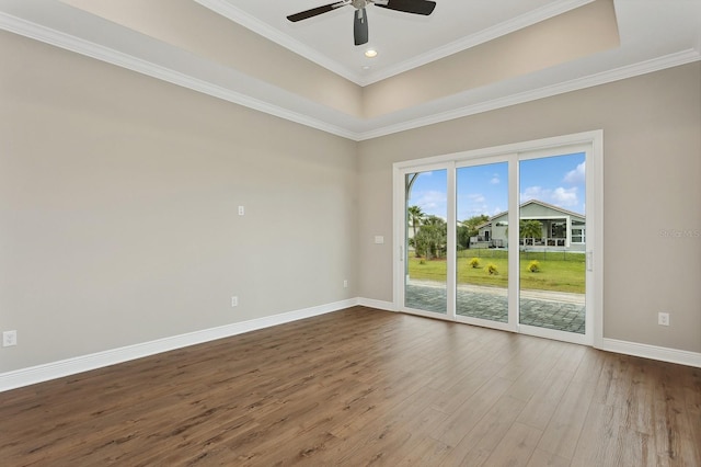 empty room with wood-type flooring, a raised ceiling, ceiling fan, and crown molding