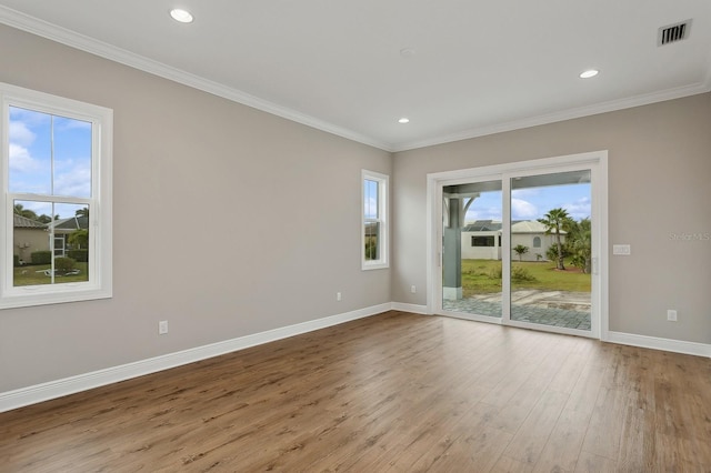 unfurnished room with ornamental molding and light wood-type flooring