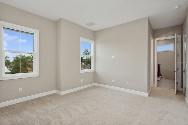 empty room with a healthy amount of sunlight and light colored carpet