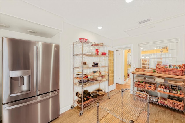 interior space with stainless steel fridge and light hardwood / wood-style flooring