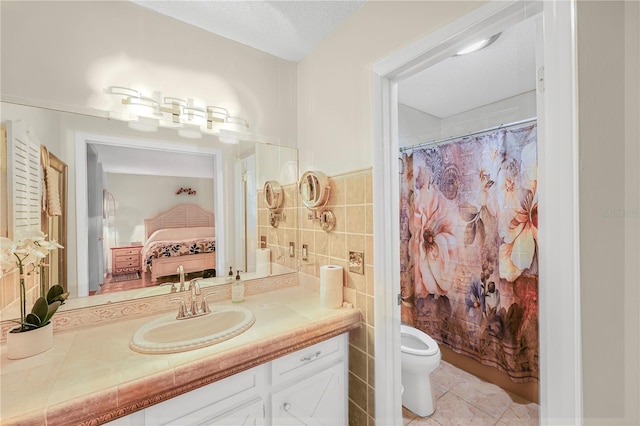 bathroom with tile walls, toilet, tile flooring, a textured ceiling, and large vanity