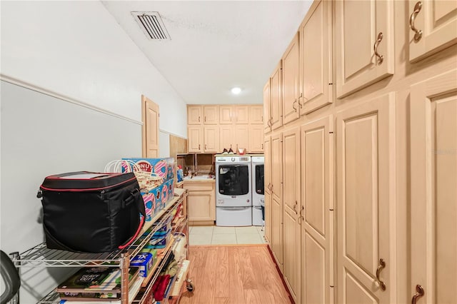 kitchen featuring washing machine and clothes dryer, light hardwood / wood-style floors, light brown cabinets, and sink