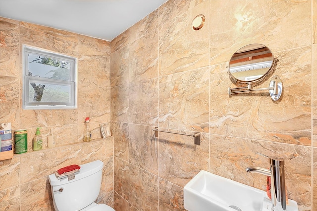 bathroom with tile walls, toilet, and sink