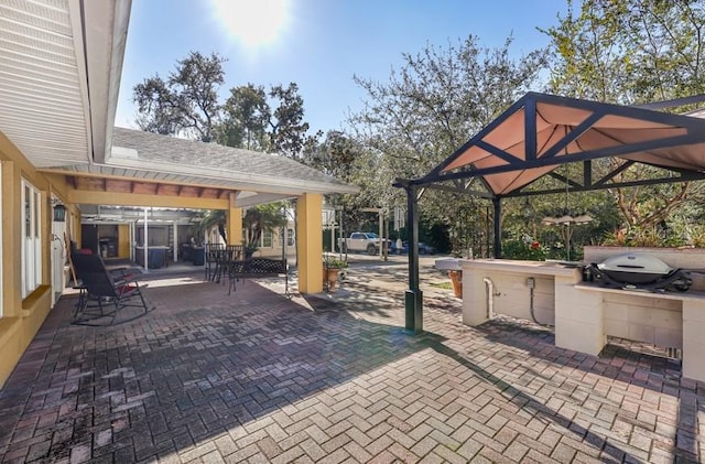 view of terrace featuring exterior kitchen, a grill, and a gazebo