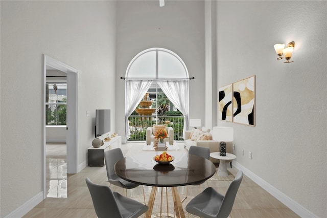 tiled dining area with a towering ceiling