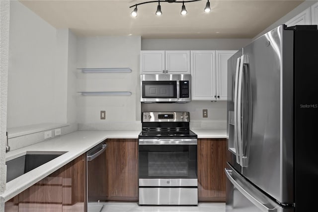 kitchen with dark brown cabinets, white cabinets, and appliances with stainless steel finishes