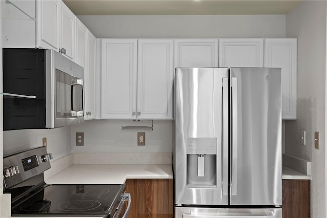 kitchen featuring stainless steel appliances and white cabinetry