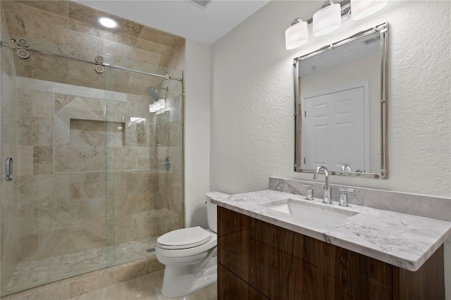 bathroom featuring toilet, an enclosed shower, and vanity