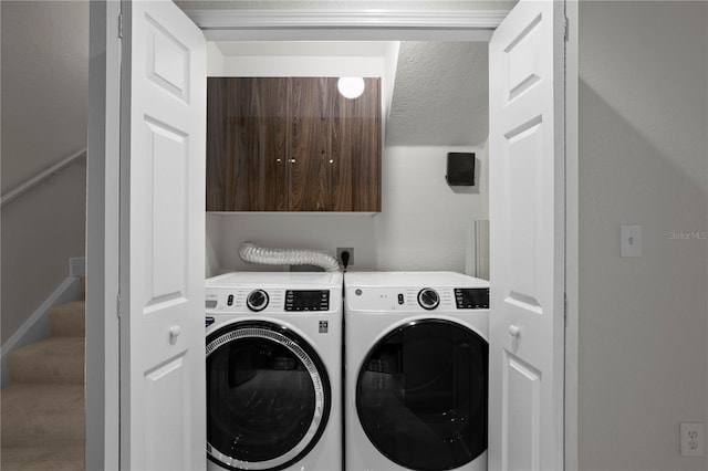 clothes washing area with cabinets, independent washer and dryer, and a textured ceiling