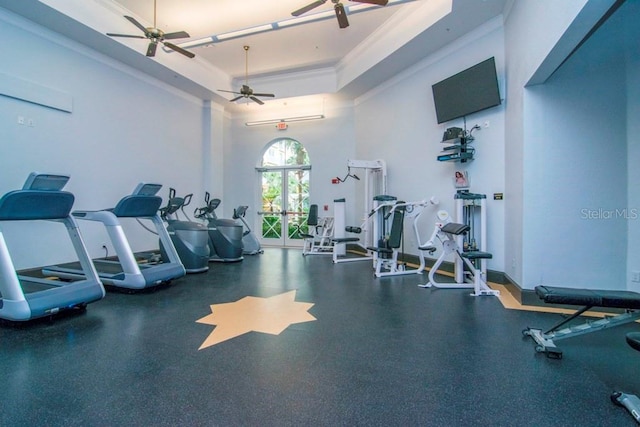 gym featuring ceiling fan, a raised ceiling, a towering ceiling, and crown molding