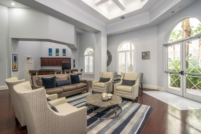 living room featuring crown molding, dark hardwood / wood-style flooring, a towering ceiling, and french doors