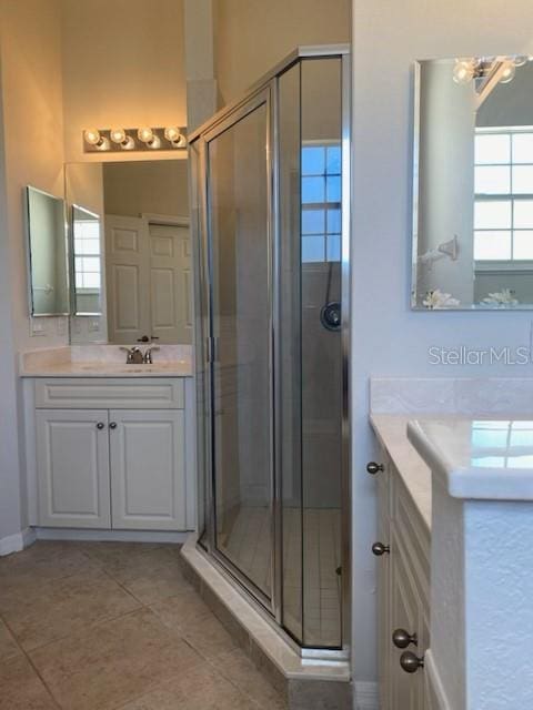 bathroom featuring tile patterned flooring, a shower stall, vanity, and an inviting chandelier